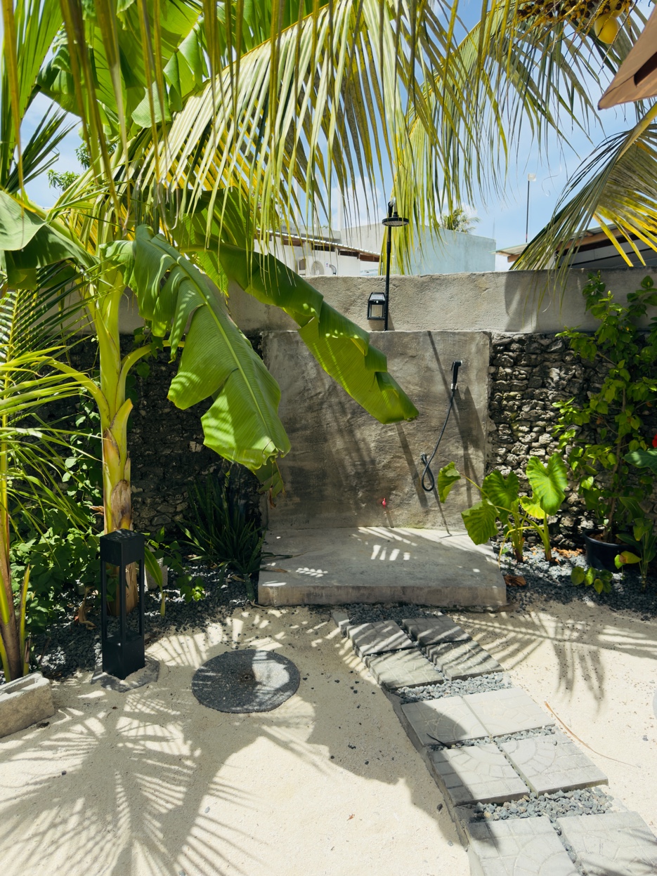 Outdoor shower surrounded by palms